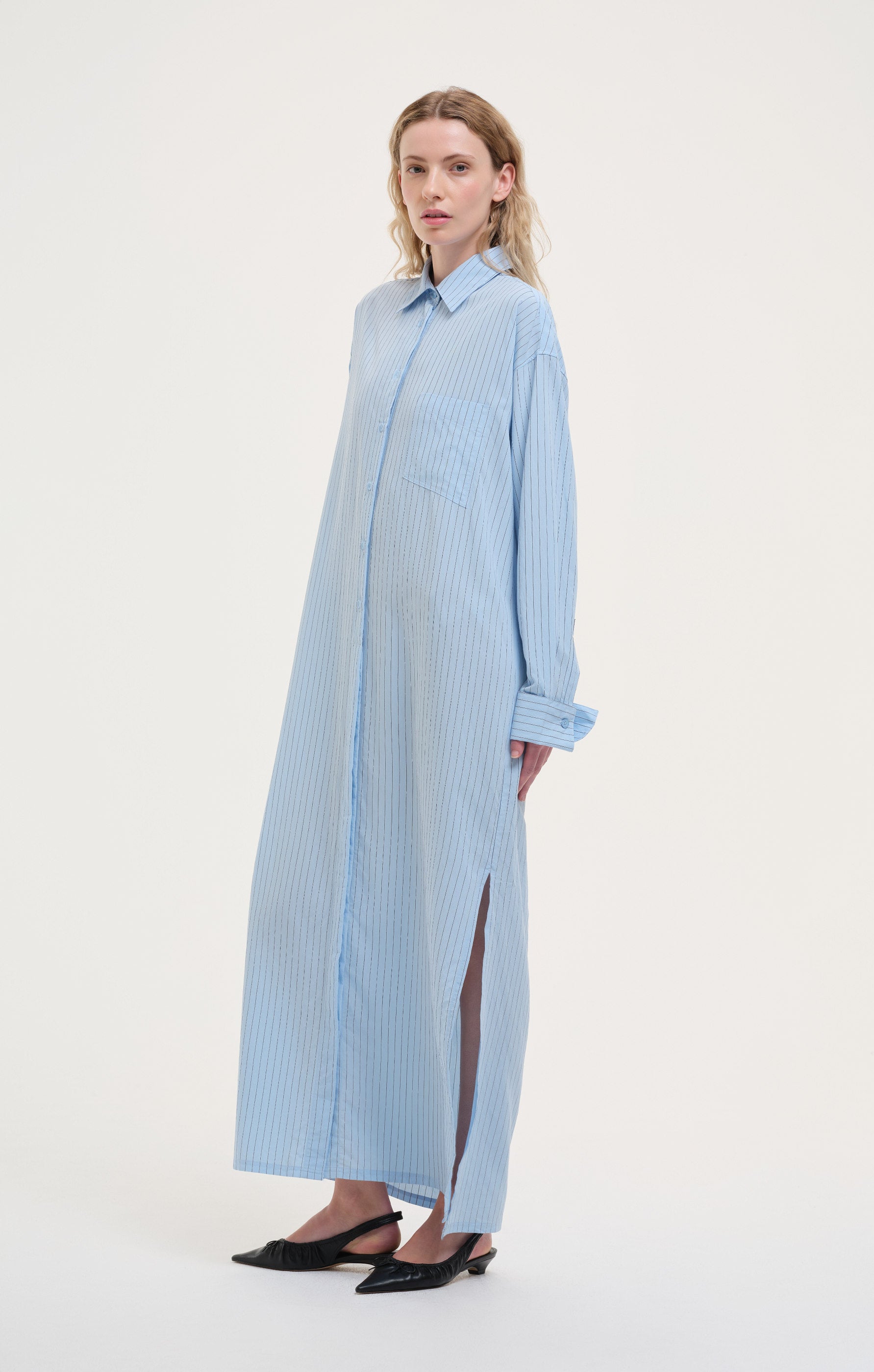Long cotton shirt dress with subtle vertical stripes, featuring a relaxed fit and lightweight, breathable feel for timeless everyday wear.
