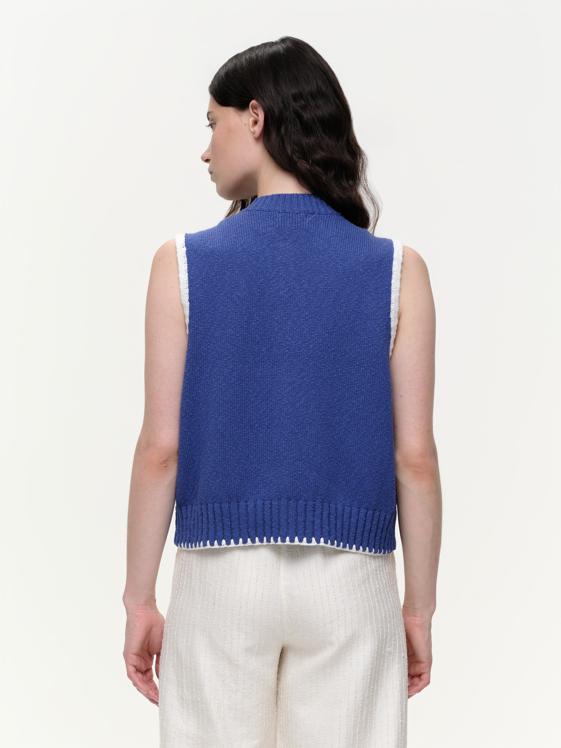 Mid-weight cotton knitted vest with a straight fit, featuring a textured twisted yarn, double-button front, and contrast blanket stitching.