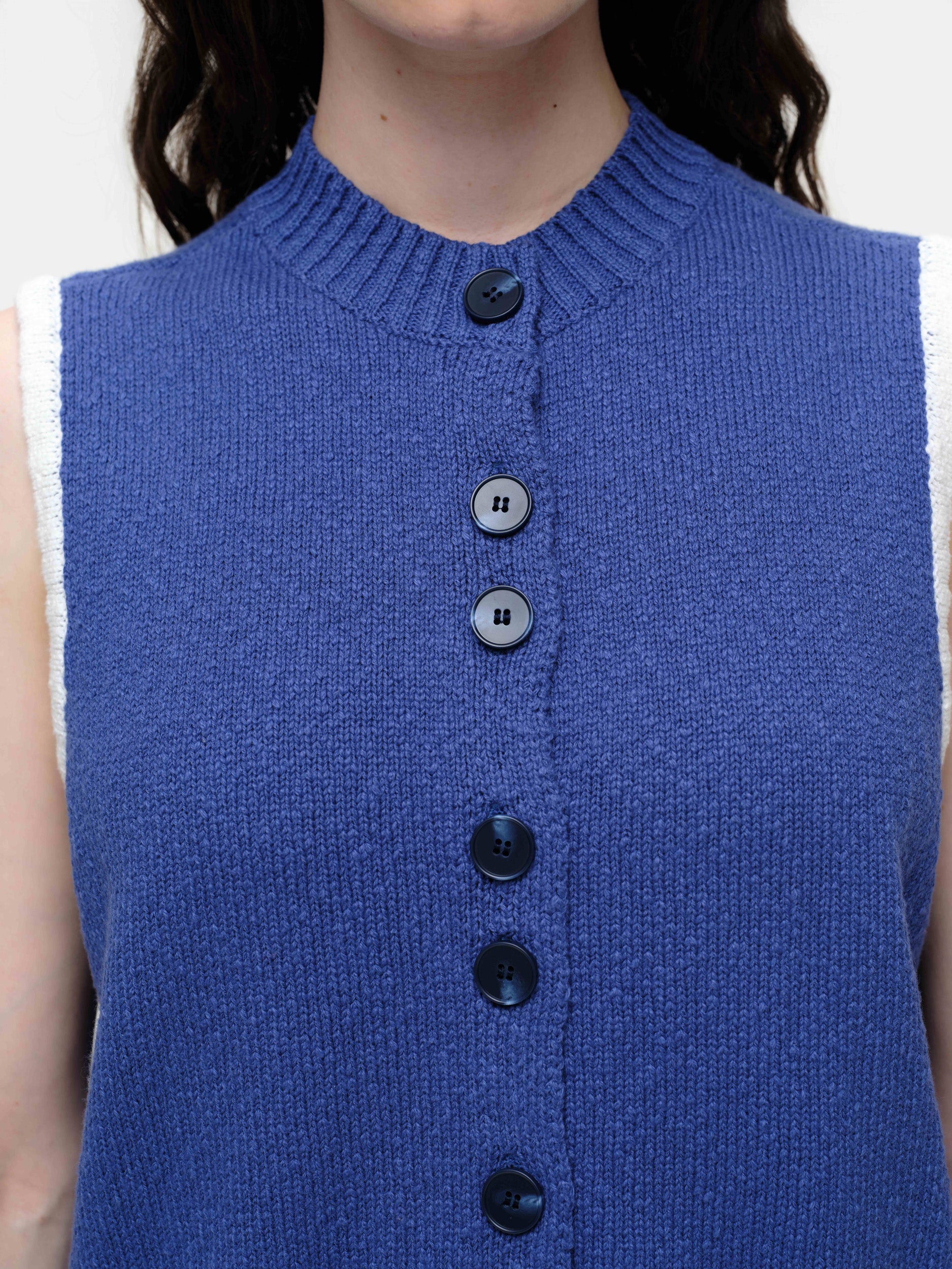 Mid-weight cotton knitted vest with a straight fit, featuring a textured twisted yarn, double-button front, and contrast blanket stitching.