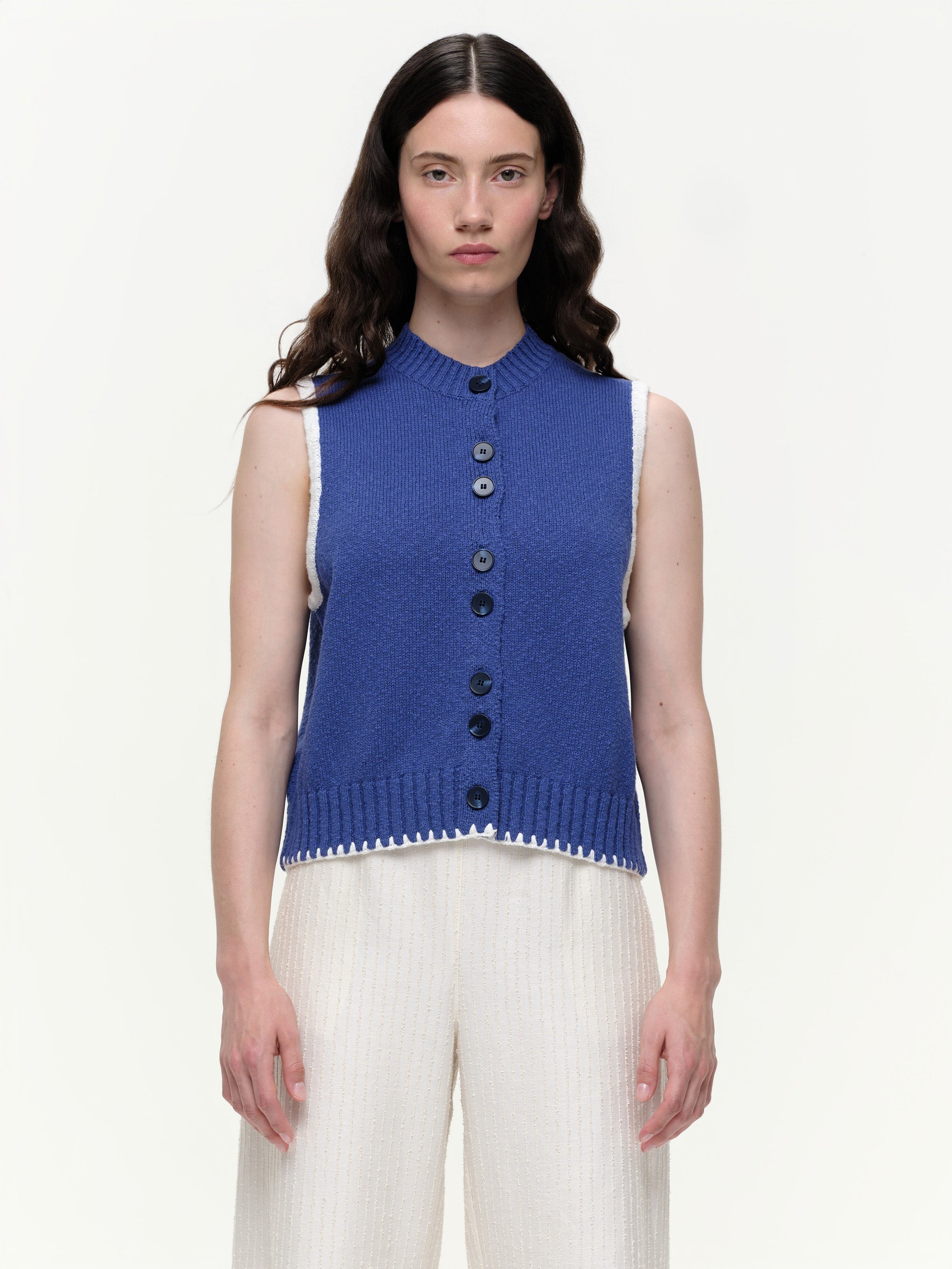Mid-weight cotton knitted vest with a straight fit, featuring a textured twisted yarn, double-button front, and contrast blanket stitching.