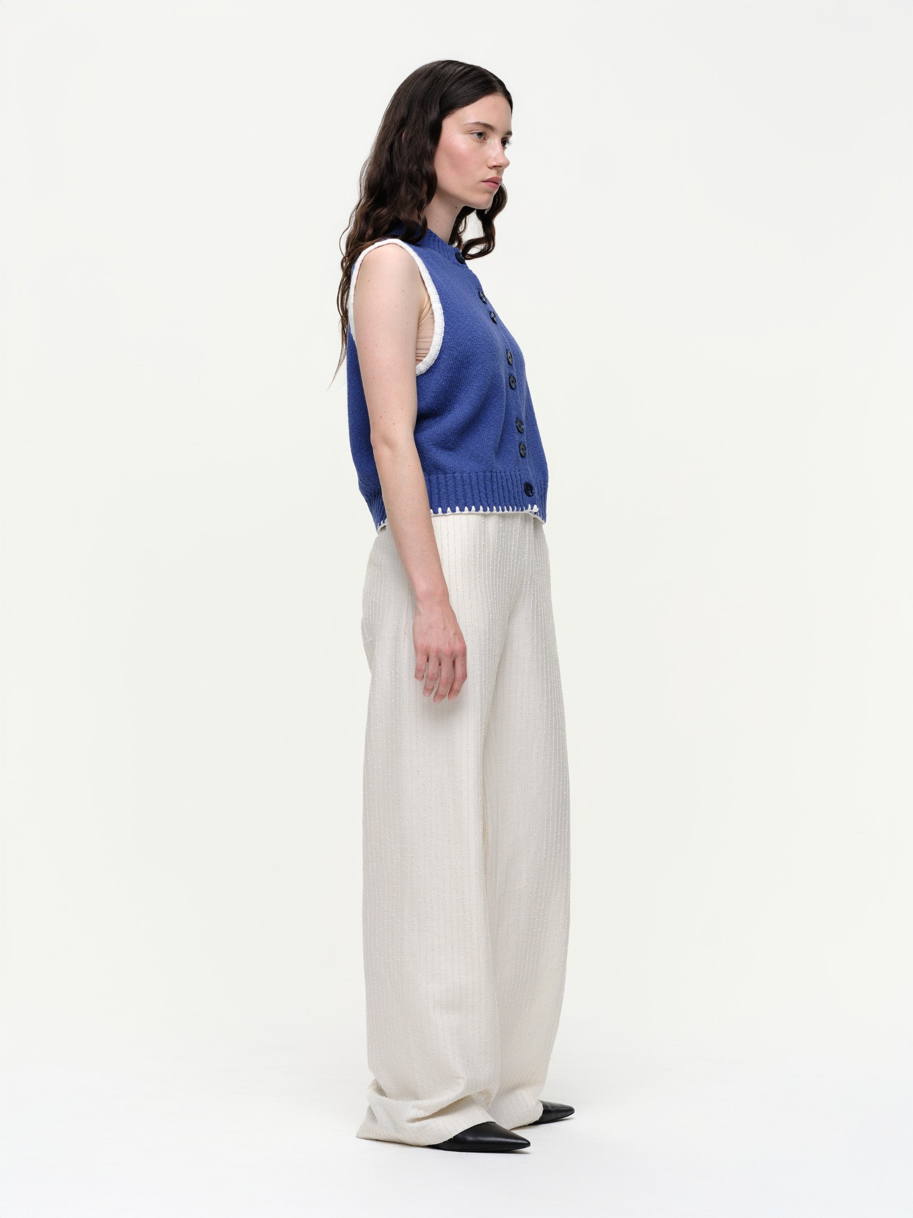 Mid-weight cotton knitted vest with a straight fit, featuring a textured twisted yarn, double-button front, and contrast blanket stitching.