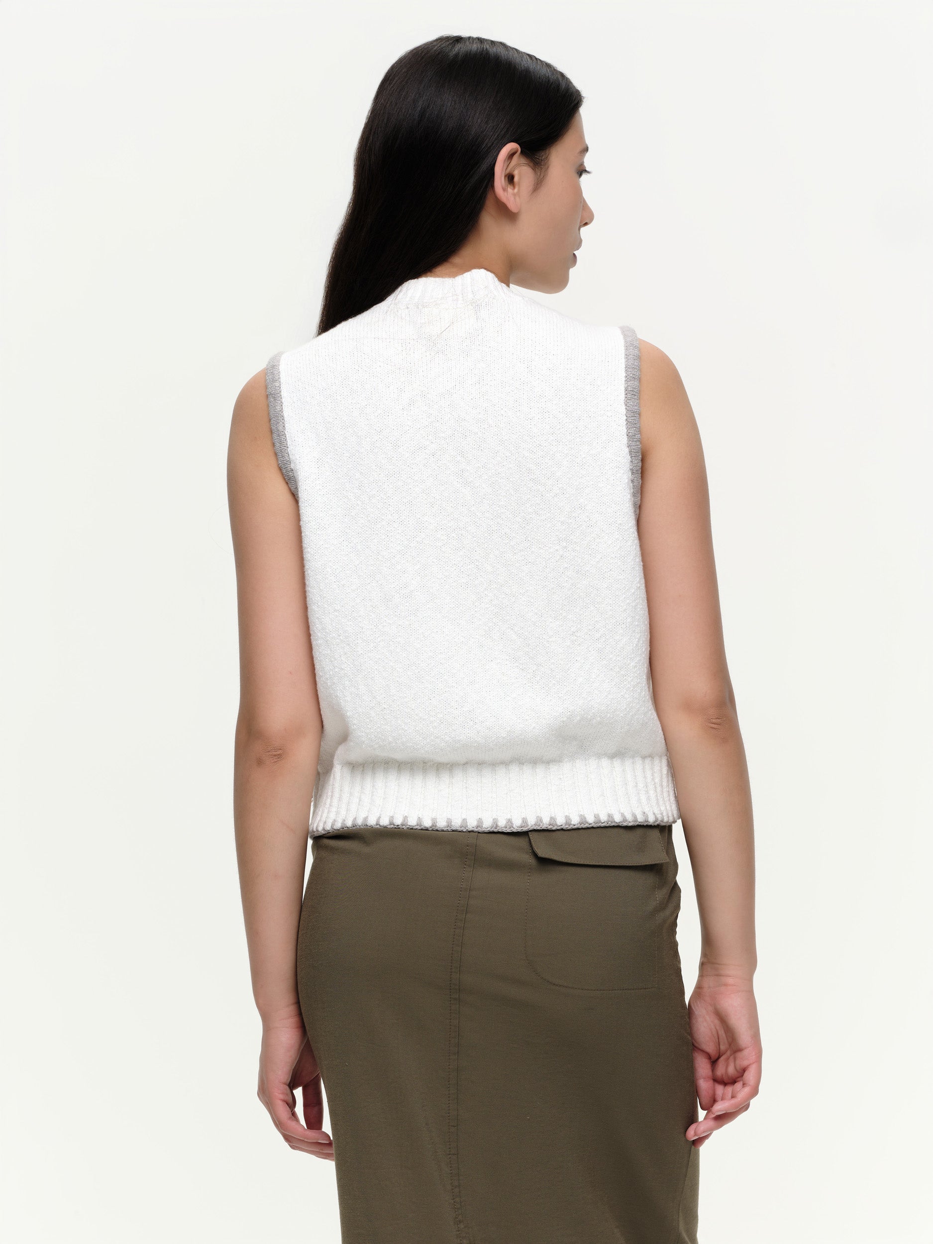 Mid-weight cotton knitted vest with a straight fit, featuring a textured twisted yarn, double-button front, and contrast blanket stitching.